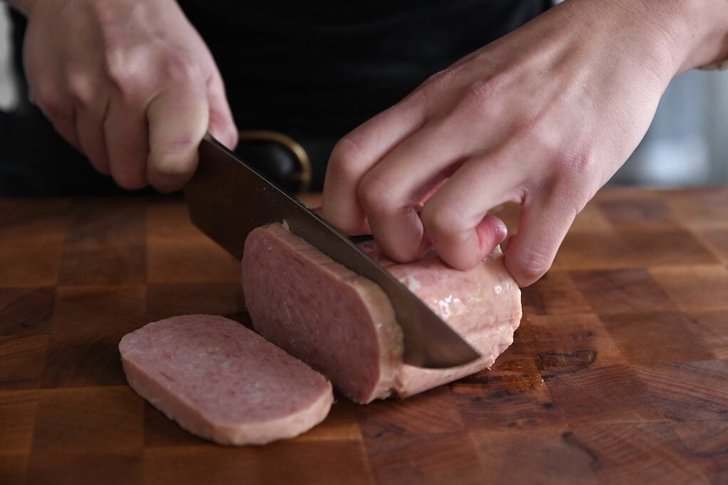 knife slicing into a piece of luncheon meat