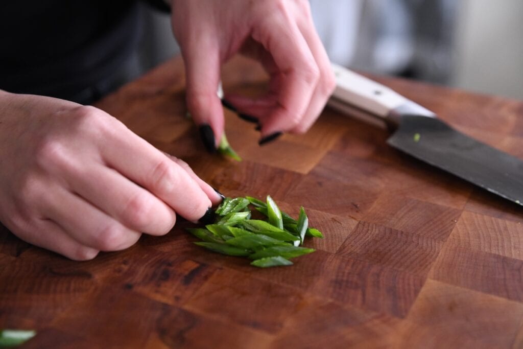 angle cut green onions on cutting board