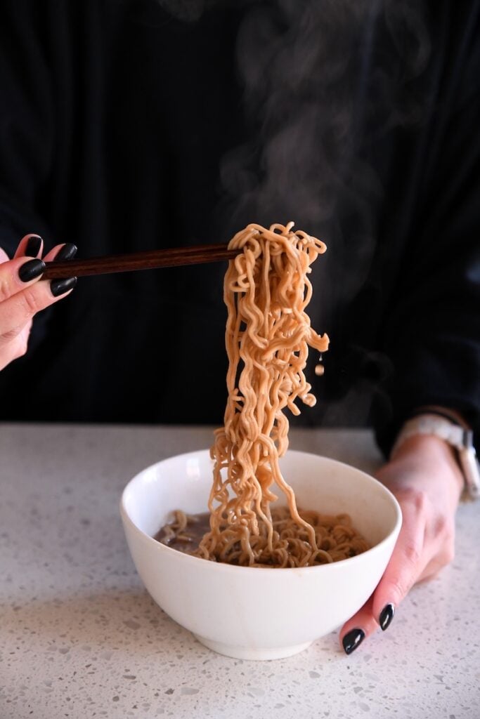 Immi Spicy Beef Ramen Soup noodle pull from chopsticks