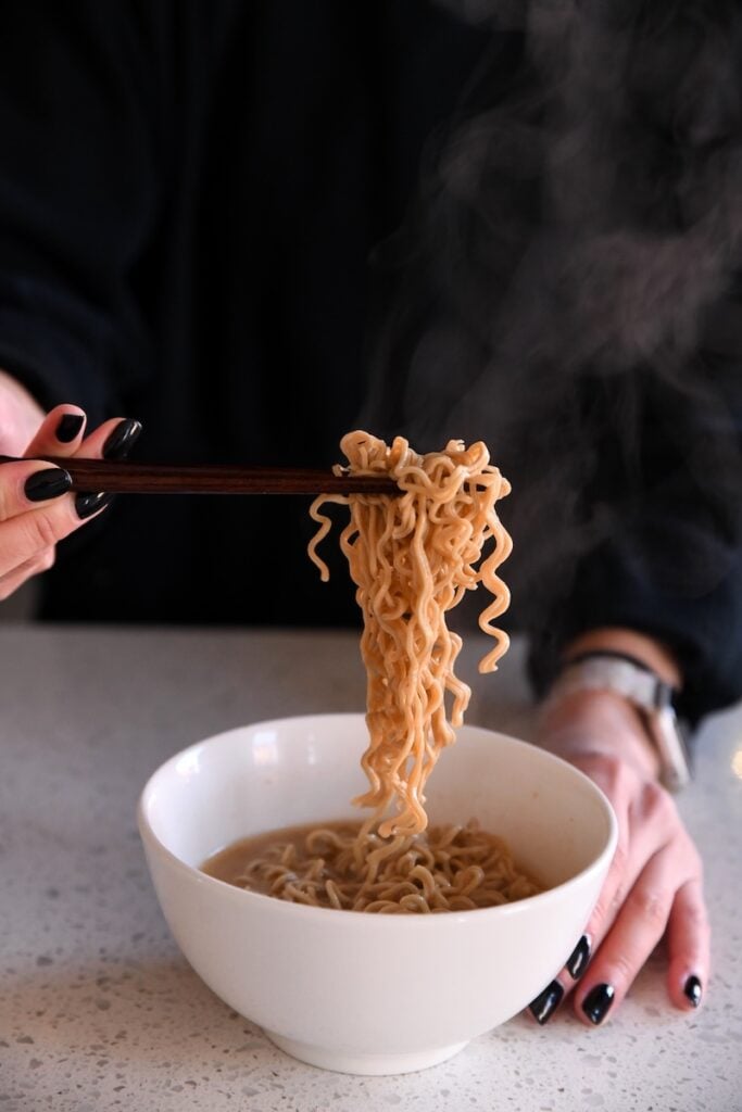 Immi spicy red miso noodle pull from chopsticks