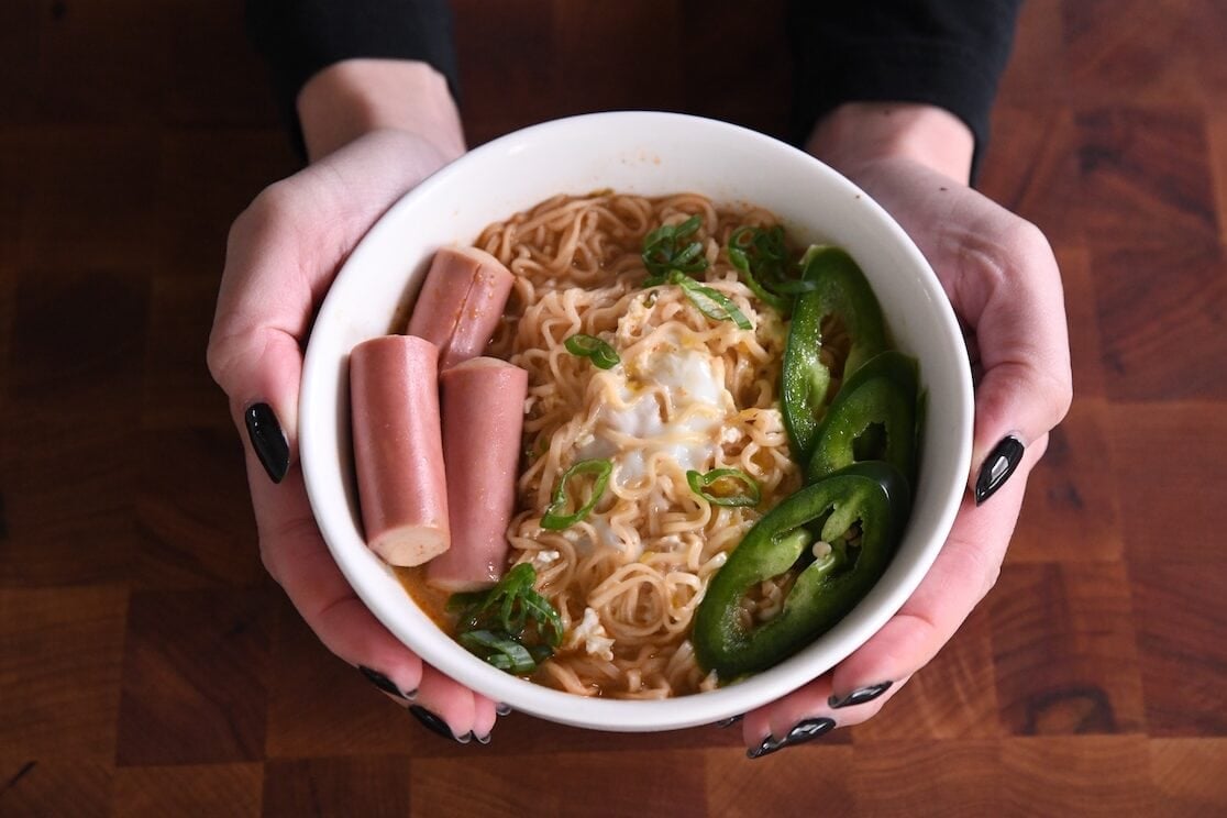 bowl of ramen topped with vienna sauces, green onions, and jalapeno slices