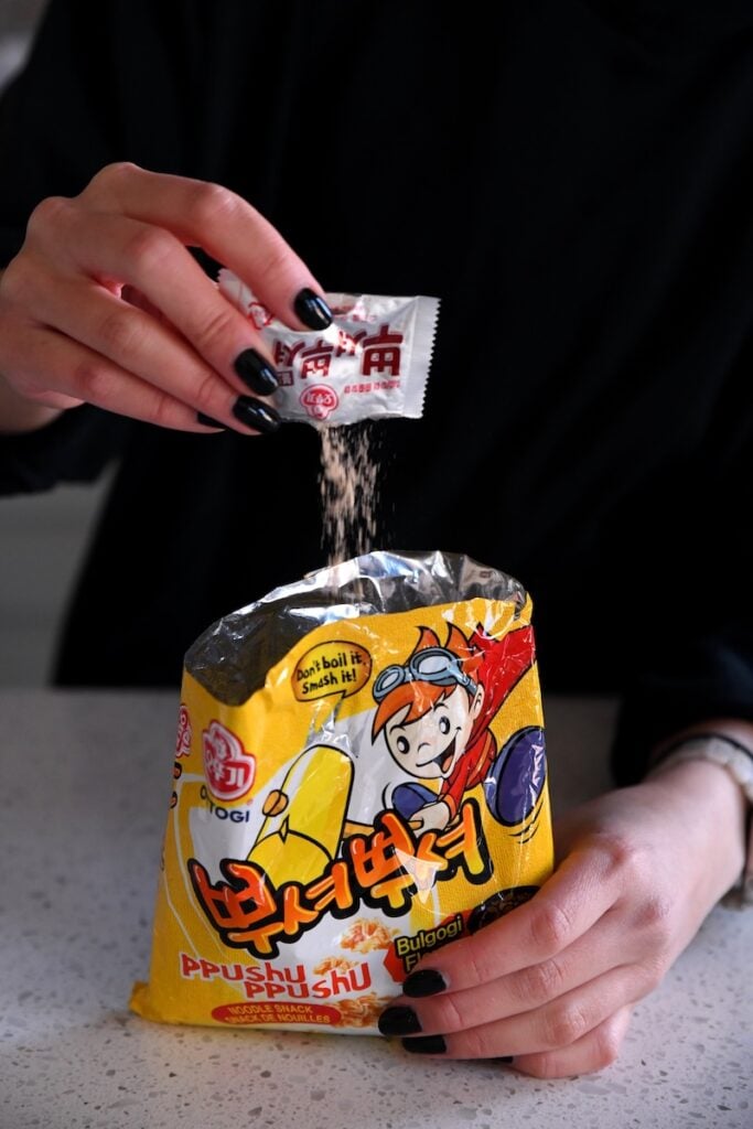 Pouring seasoning packet into package