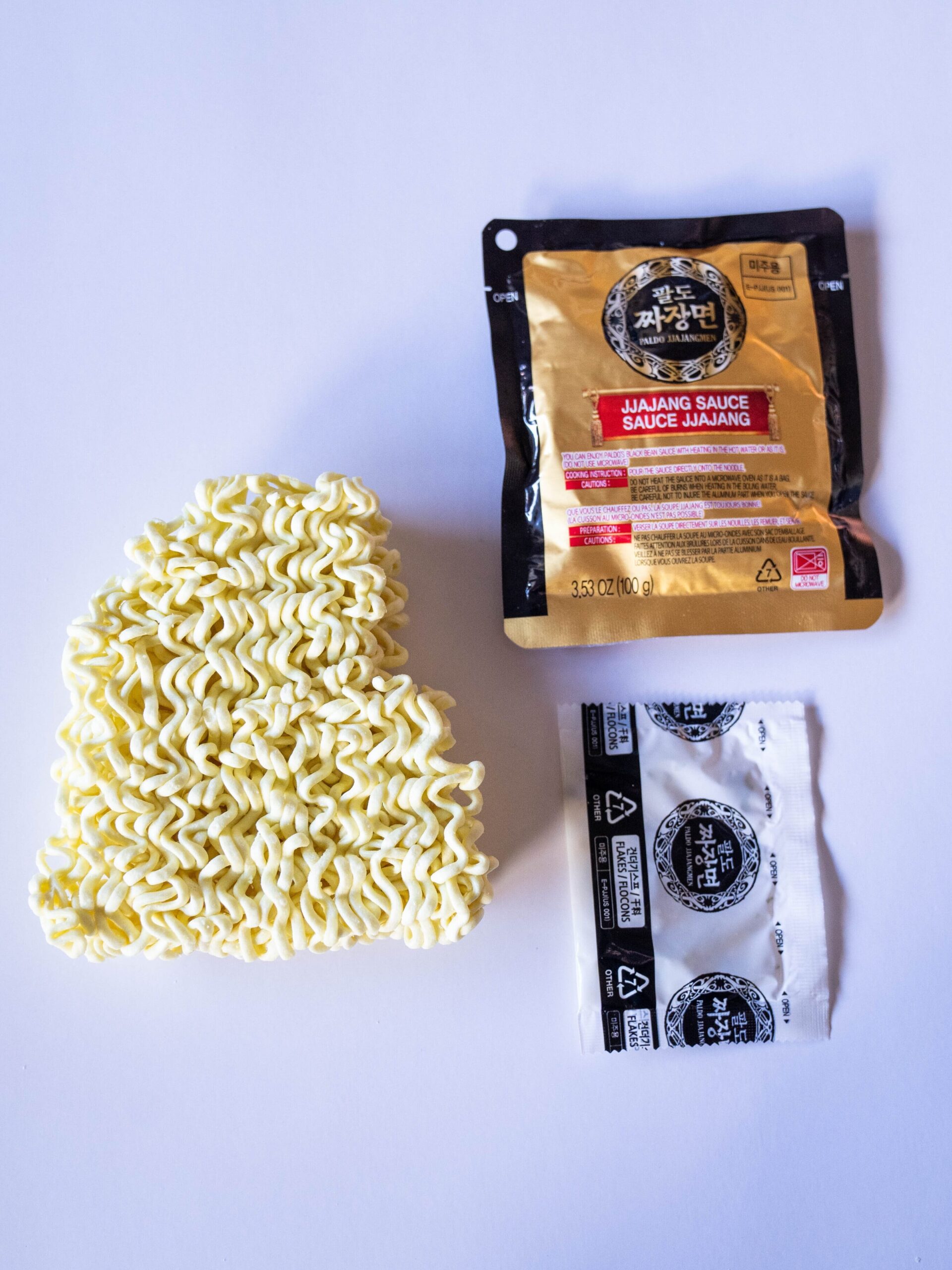 Slightly broken noodle brick with Jjajang sauce packet and oil packet
