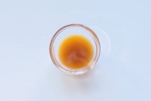 Nongshim Shin Ramyun Spicy Noodle Soup broth in a glass ramekin showing golden color