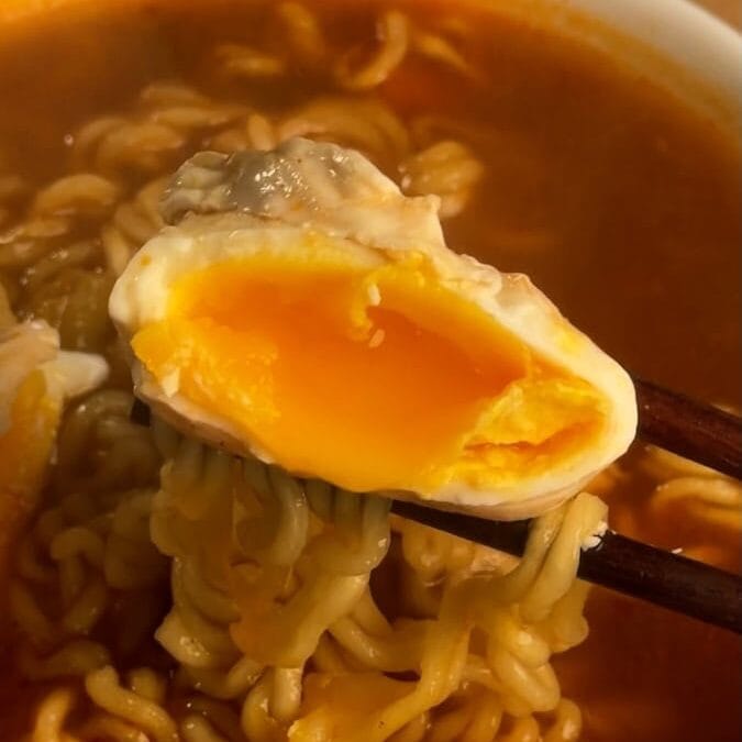 running egg yolk held by chopsticks