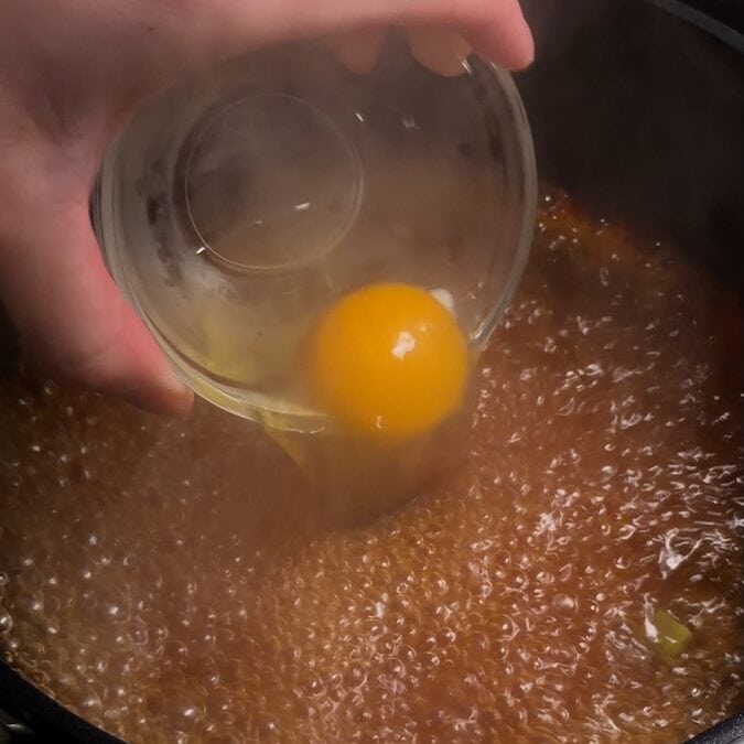 egg pour into boiling broth