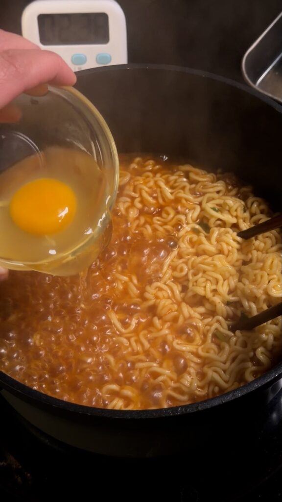 egg pour into ramen noodles