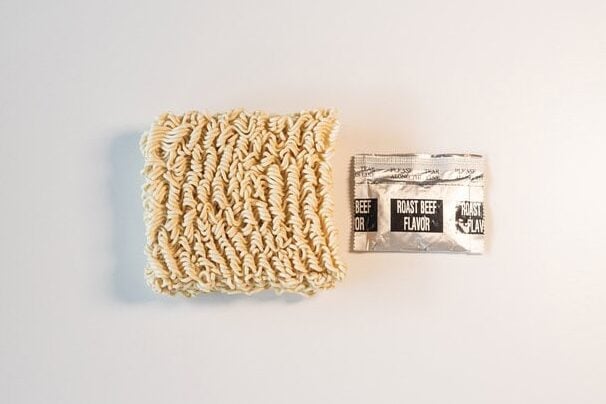 Maruchan Roast Beef Ramen noodle block and seasoning packet laid out on white surface