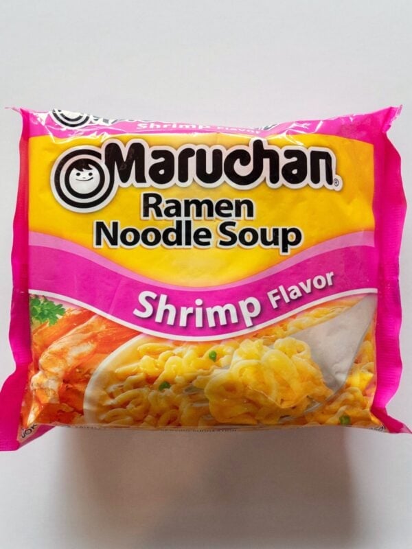 The pink and yellow package of Maruchan Shrimp Flavor Ramen Noodle Soup on a white surface