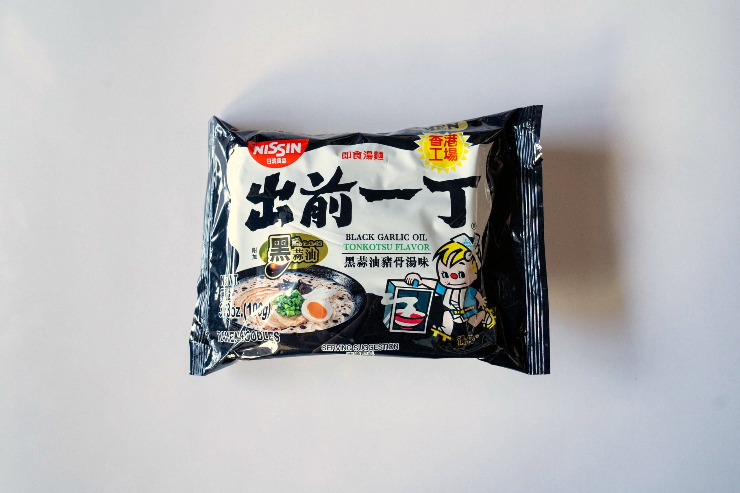 Nissin Demae Black Garlic Oil Tonkotsu Flavor noodle package on a white background