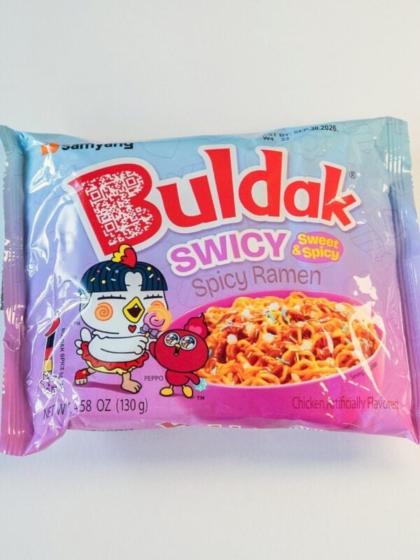 The pink and blue package of Samyang Buldak SWICY Sweet & Spicy Ramen on a white surface